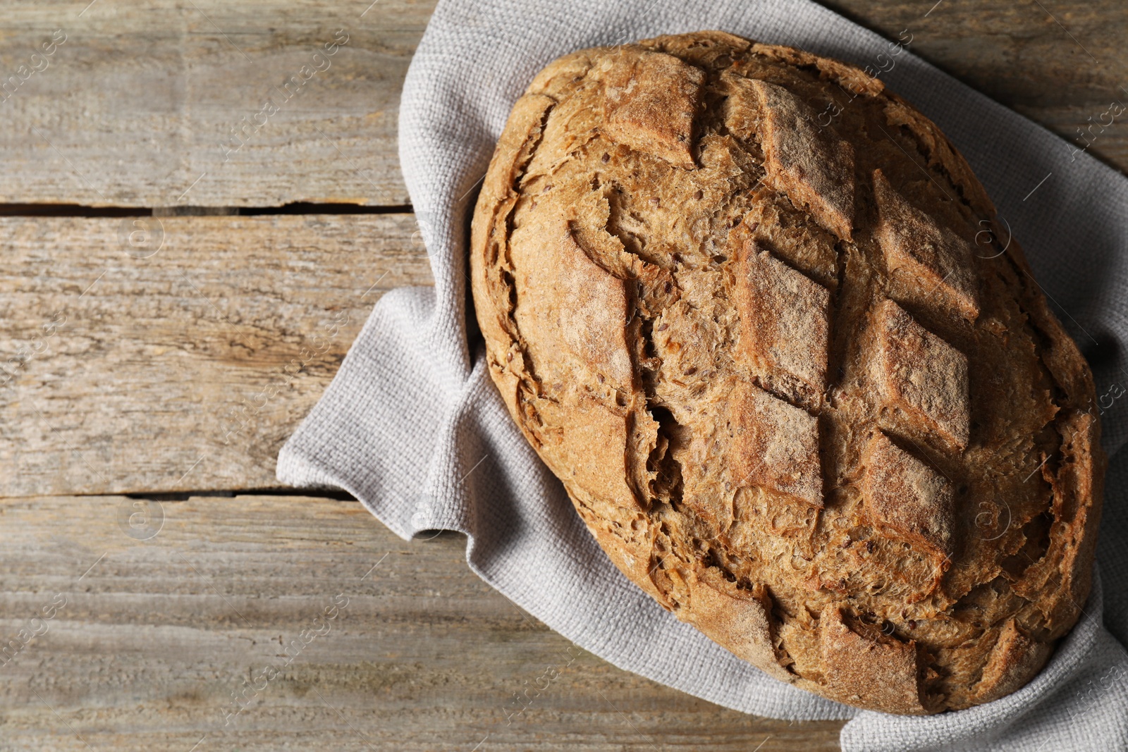 Photo of Freshly baked sourdough bread on wooden table, top view. Space for text