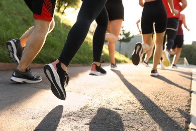 Group of people running outdoors on sunny day, closeup
