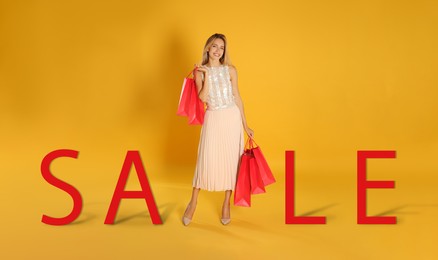 Image of Happy young woman with shopping bags and word SALE on yellow background