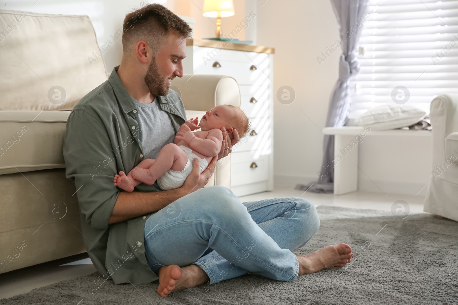 Photo of Father with his newborn son at home