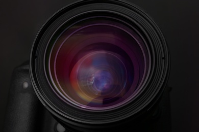 Photo of Lens of professional camera on black background, closeup