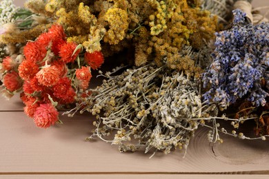 Photo of Different medicinal herbs on wooden table, closeup