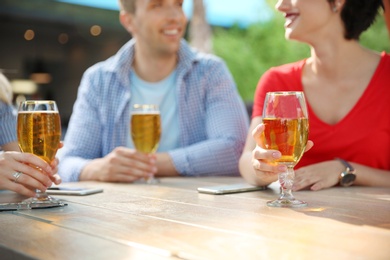 Young people with glasses of cold beer at table