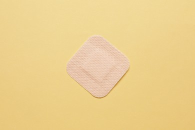 Photo of Contraceptive patch on yellow background, top view