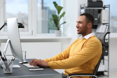 Young man working on computer at table in office