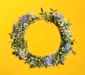 Beautiful handmade flower wreath on yellow background