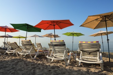 Photo of Many colorful beach umbrellas and sunbeds at resort