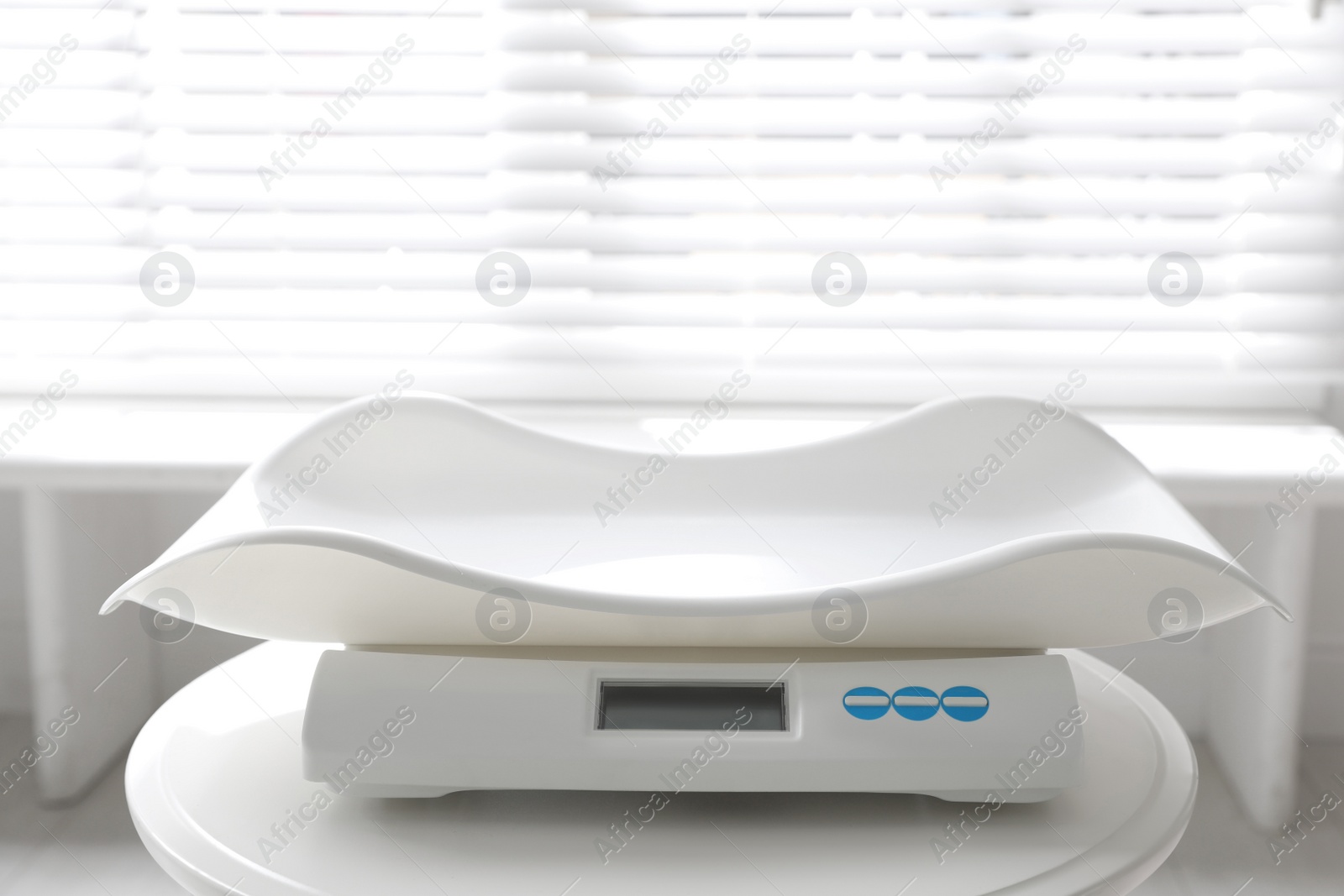 Photo of Modern digital baby scales on table in room