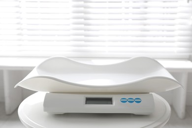 Modern digital baby scales on table in room