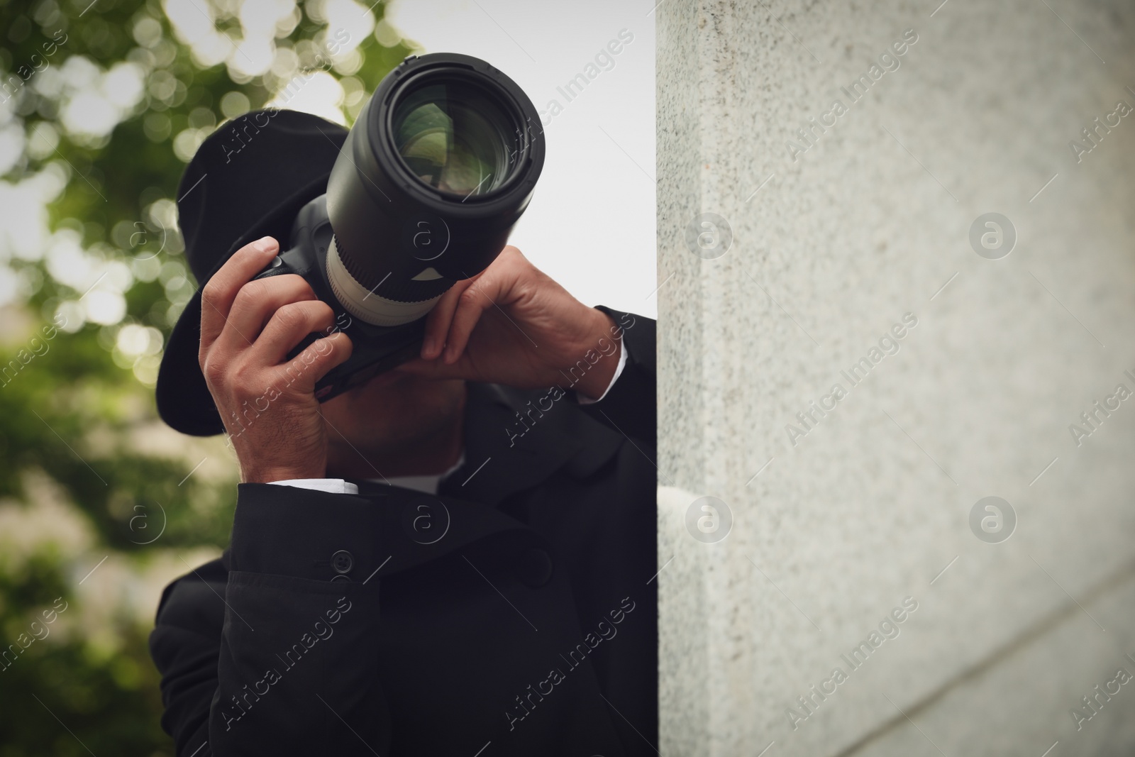 Photo of Private detective with modern camera spying on city street