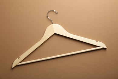 Photo of Empty wooden hanger on brown background, top view