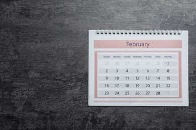 February calendar on grey stone background, top view. Space for text