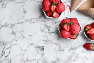 Photo of Yummy strawberry ice cream served on white marble table, flat lay. Space for text