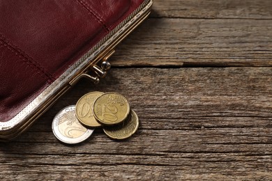Photo of Poverty. Wallet and coins on wooden table, closeup. Space for text