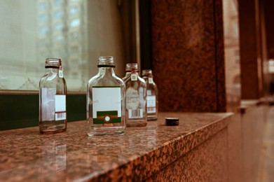 Many small glass bottles near window outdoors