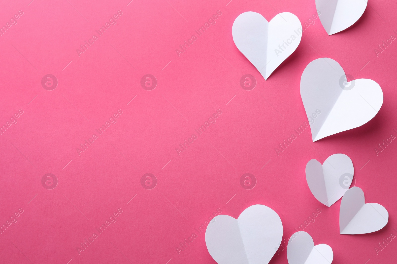 Photo of Paper hearts on pink background, flat lay. Space for text