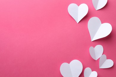 Photo of Paper hearts on pink background, flat lay. Space for text