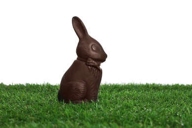 Chocolate bunny on green grass against white background. Easter celebration