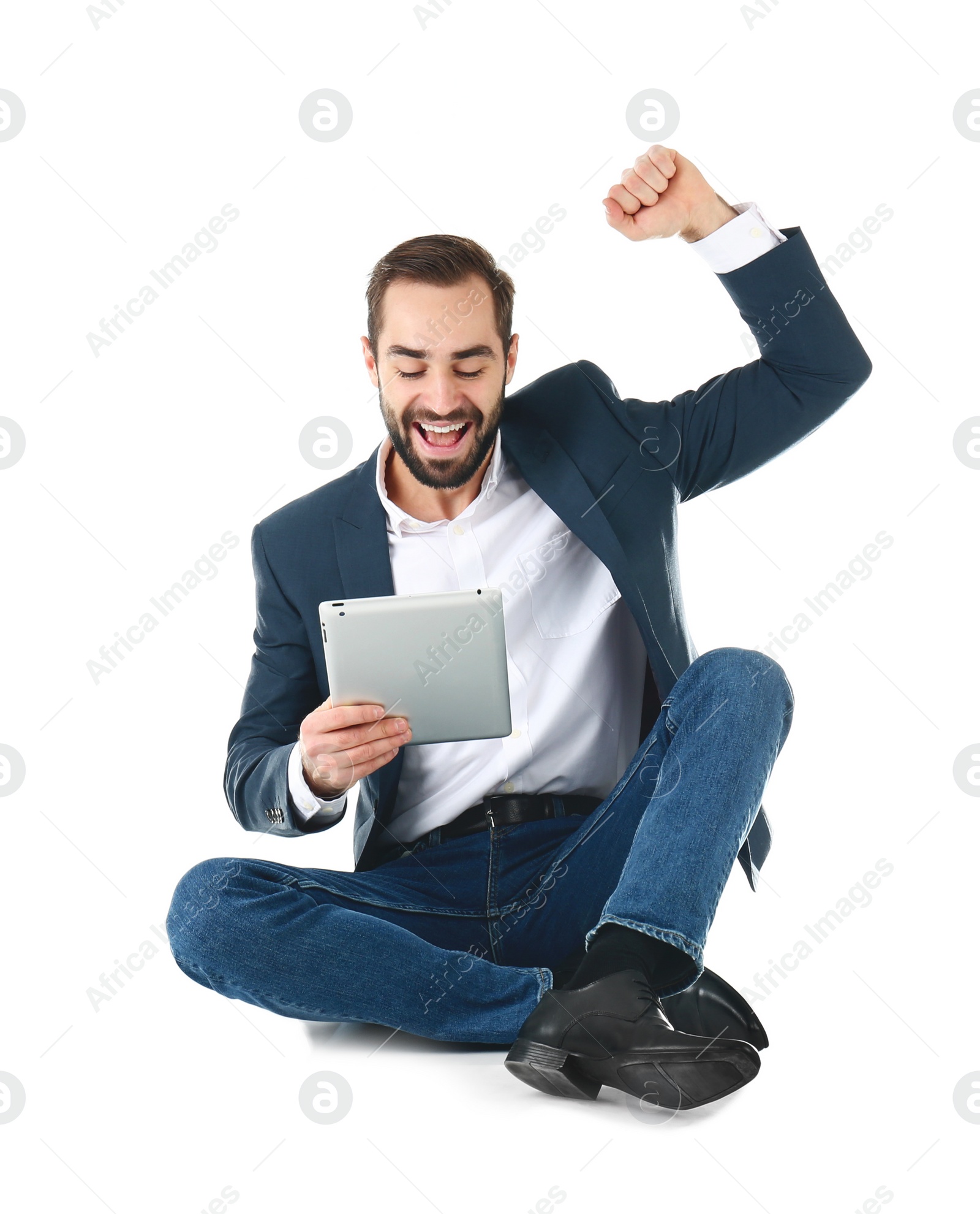 Photo of Emotional businessman in office wear with tablet celebrating victory on white background