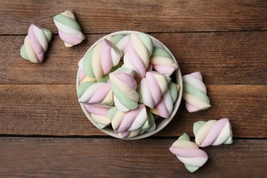 Bowl with colorful marshmallows on wooden table, flat lay