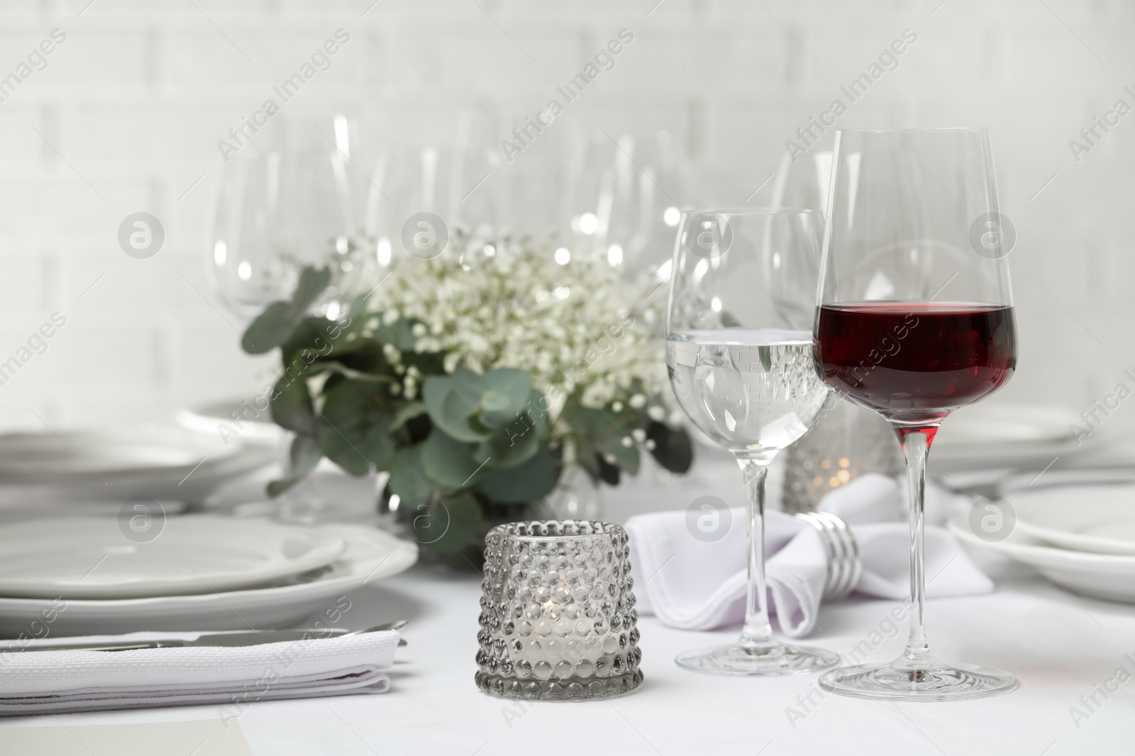 Photo of Glass of delicious wine and elegant table setting in restaurant