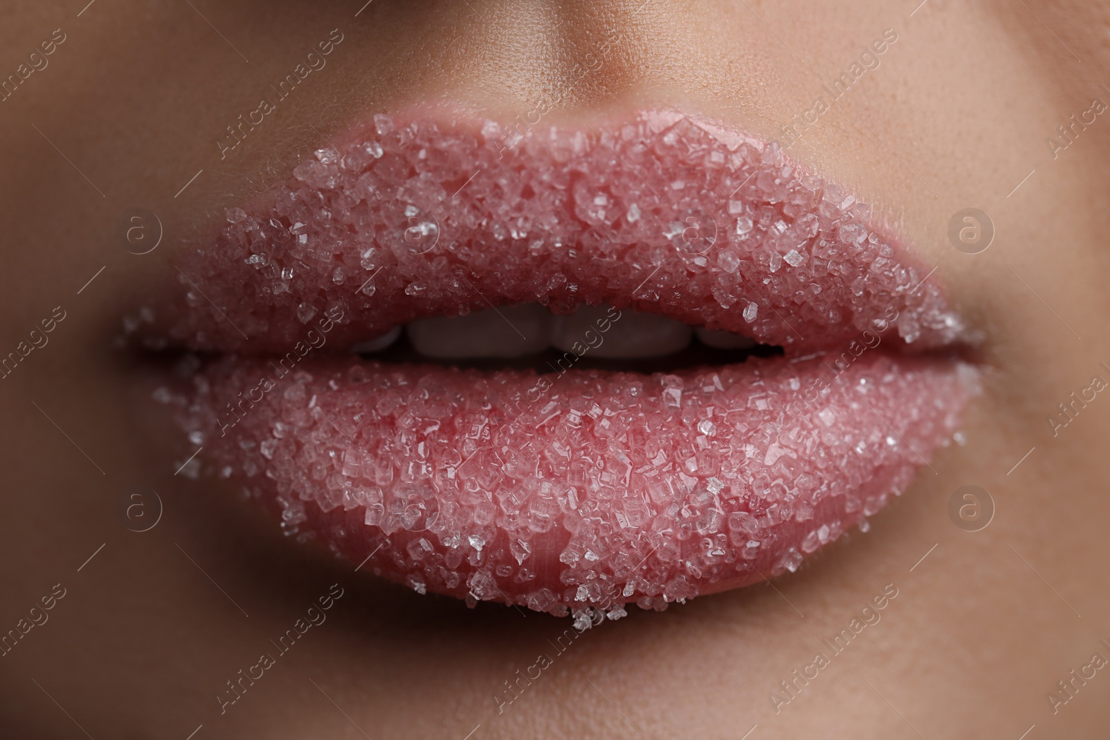 Photo of Young woman with beautiful lips covered in sugar, closeup