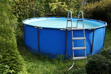 Above ground swimming pool on grass in backyard