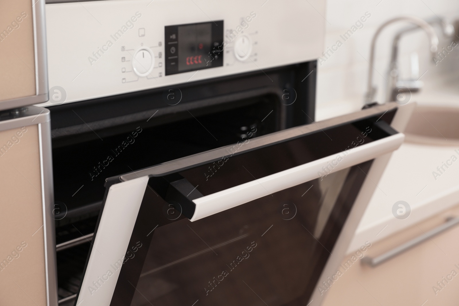 Photo of Modern electric oven with open door in kitchen