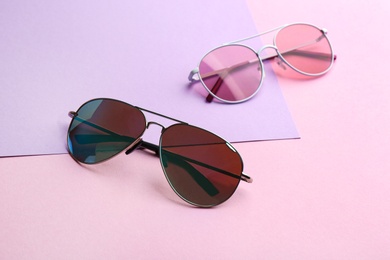 Photo of Stylish sunglasses on color background. Summer time