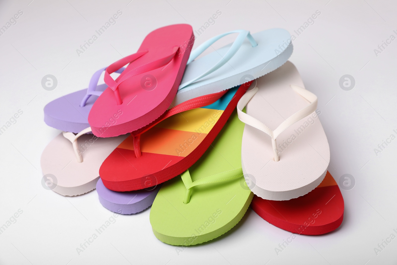 Photo of Many different flip flops on white background