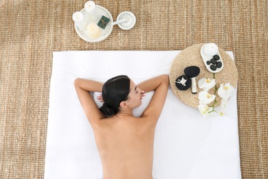 Photo of Young woman relaxing in spa salon, top view
