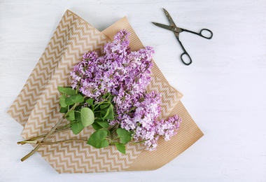 Photo of Flat lay composition with beautiful blossoming lilac on light background. Spring flowers