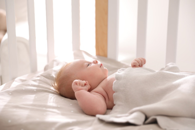 Photo of Cute little child lying in cot. Healthy baby