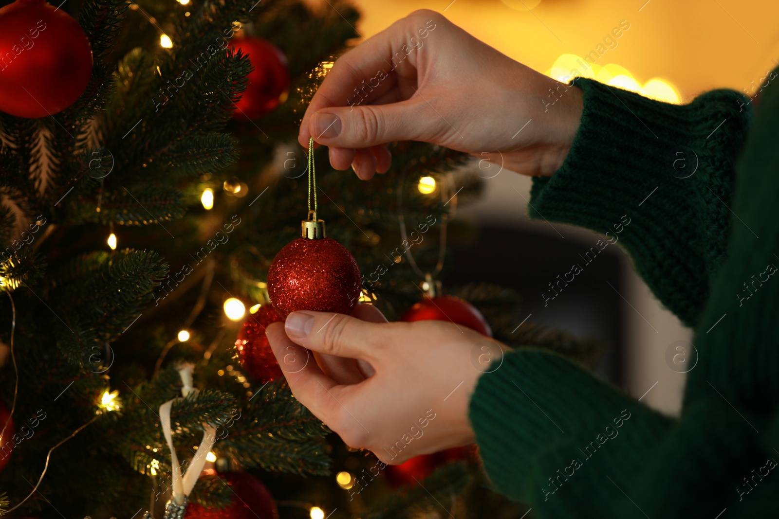 Photo of Woman decorating Christmas tree at home, closeup