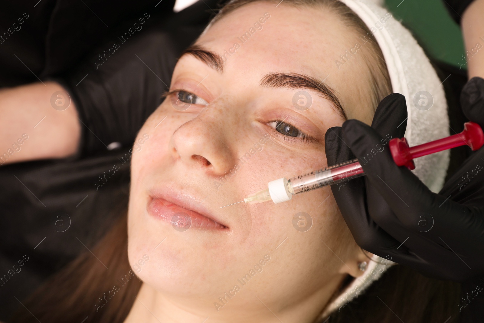 Photo of Cosmetologist giving facial injection to patient, closeup. Cosmetic surgery