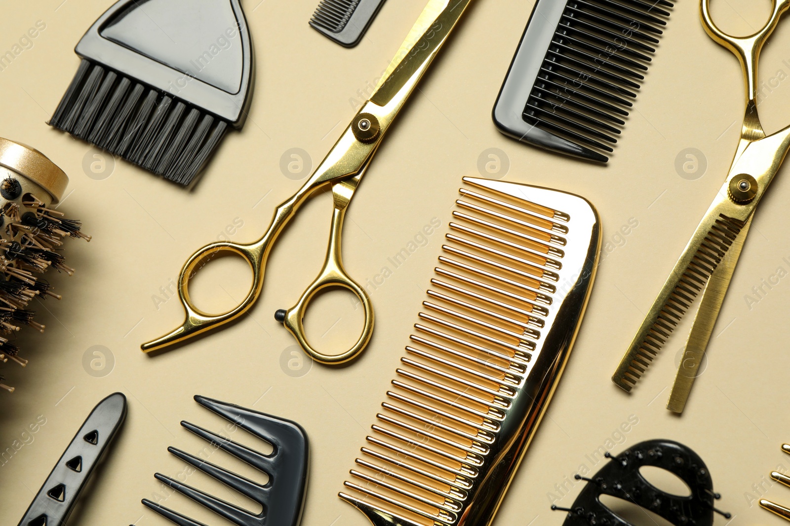 Photo of Hairdressing tools on beige background, flat lay