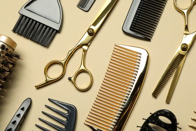 Hairdressing tools on beige background, flat lay