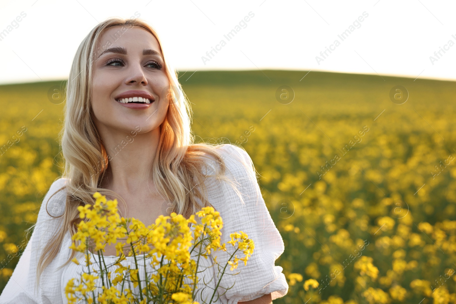 Photo of Portrait of happy young woman in field on spring day