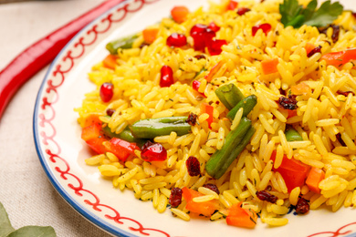 Photo of Tasty rice pilaf with vegetables on table, closeup