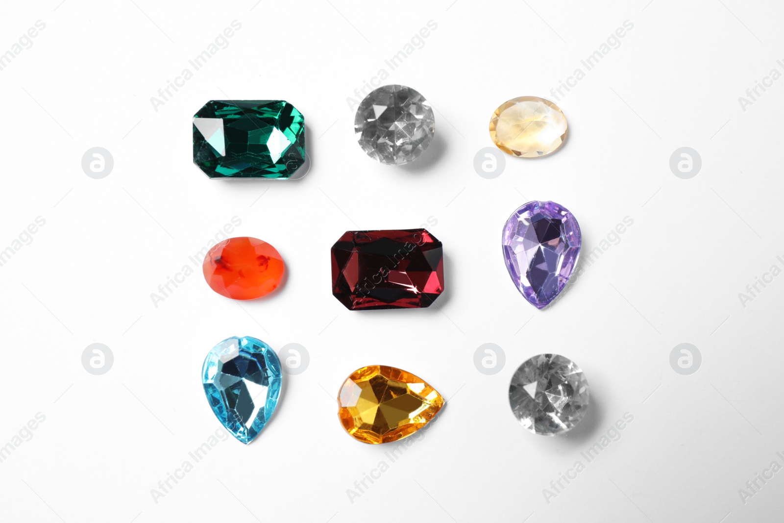 Photo of Different beautiful gemstones on white background, top view