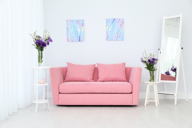 Modern interior of living room with comfortable sofa near white wall