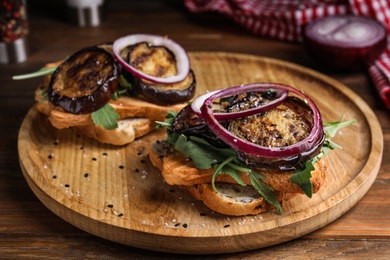 Delicious fresh eggplant sandwiches served on wooden table