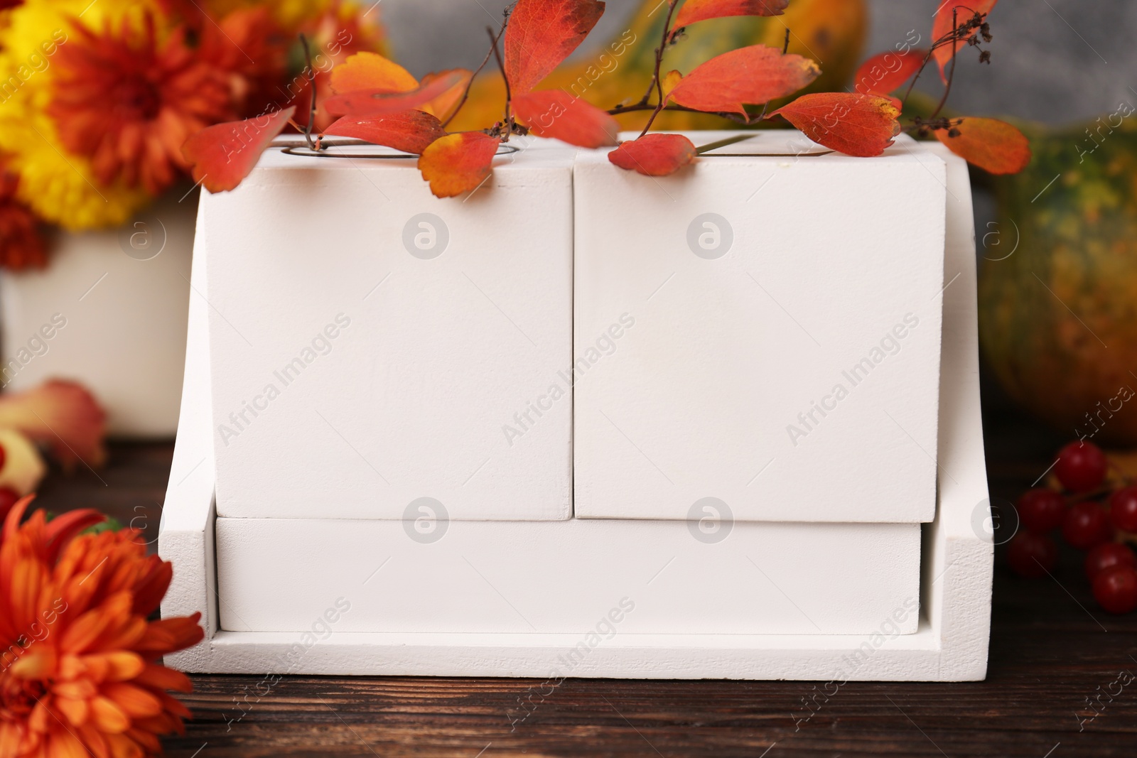 Photo of Thanksgiving day, holiday celebrated every fourth Thursday in November. Block calendar and autumn leaves on wooden table, closeup