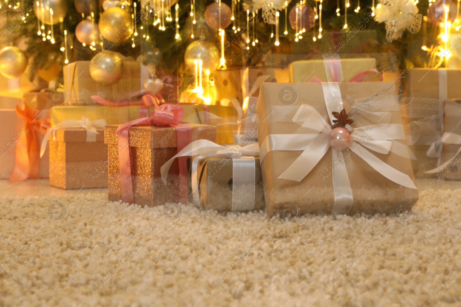 Photo of Many gift boxes under decorated Christmas tree at home, motion blur effect