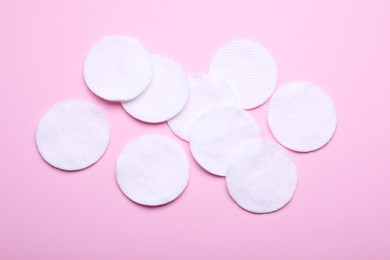 Soft clean cotton pads on pink background, flat lay