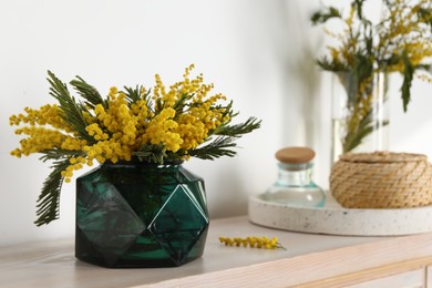 Beautiful mimosa flowers on wooden table indoors, space for text