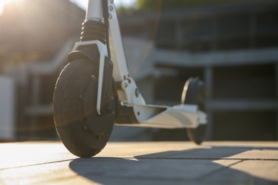 Modern electric kick scooter outdoors on sunny day, closeup