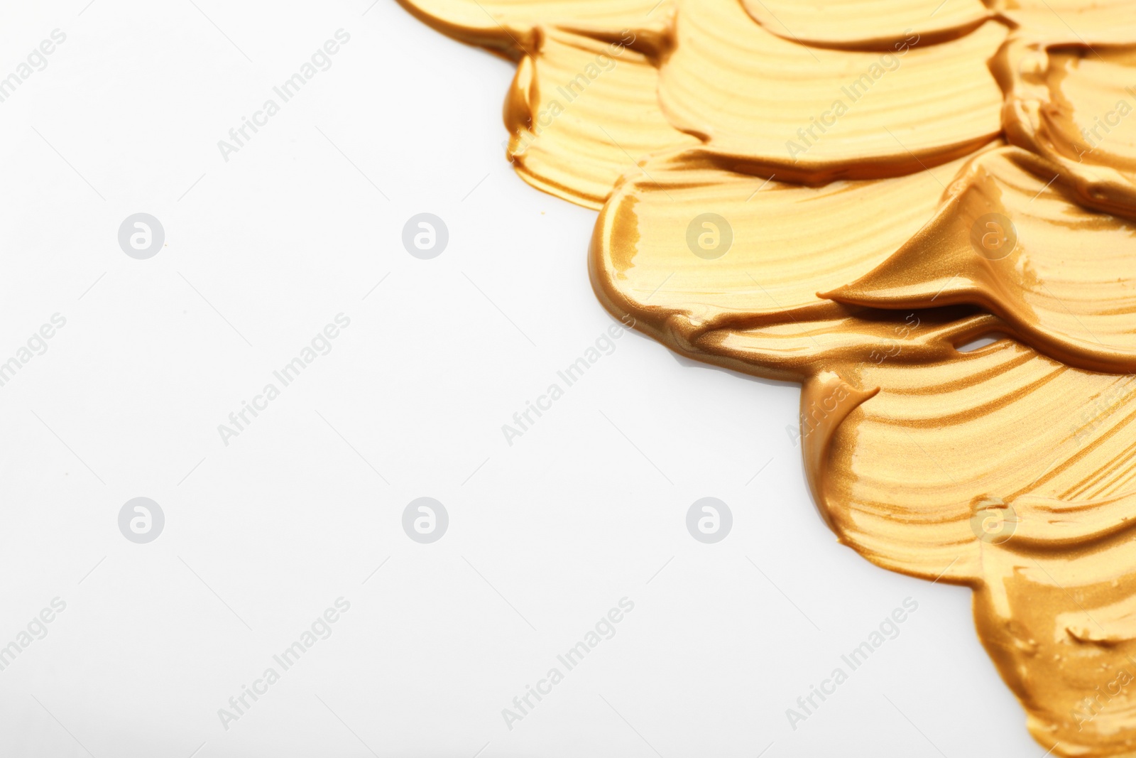 Photo of Strokes of gold paint isolated on white