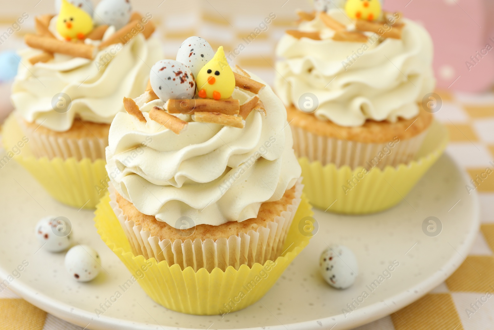 Photo of Tasty Easter cupcakes with vanilla cream on table, closeup