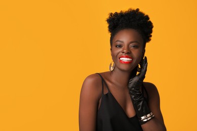 Fashionable portrait of beautiful happy woman on yellow background, space for text